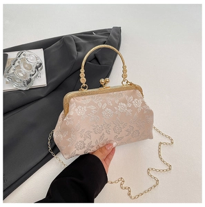 Detail of pink satin handbag with floral embroidery and gold metal clasp handle