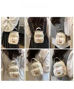 Mini white backpack with pink rabbit patterns featuring gold chain straps and twist lock