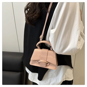 Close-up of pink lychee leather mini crossbody bag with top handle and strap