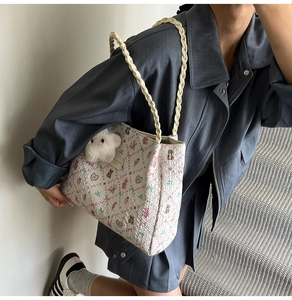Dettaglio della tote trapuntata bianca con stampe di orsi colorati e ciondolo di peluche