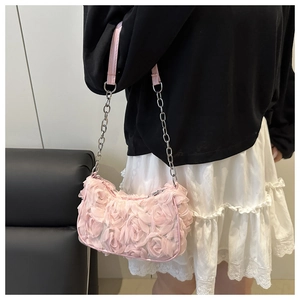 Detail van roze stoffen rozen op de schoudertas met zilveren metalen ketting