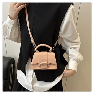 Detail of pink lychee grain leather mini handbag with top handle and crossbody strap