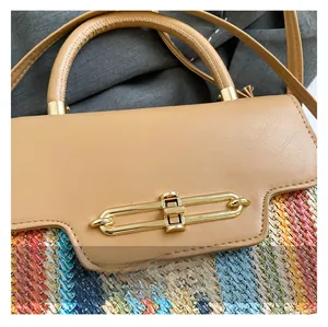 Detail of color-block leather flap and woven straw texture with gold oval clasp