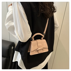 Close-up of pink lychee grain leather handbag with top handle and shoulder strap detail