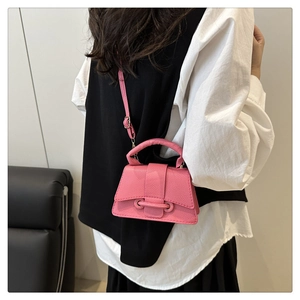 Detail of pink hourglass crossbody bag with lychee texture and adjustable strap