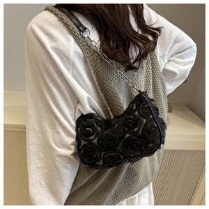 Detail of 3D rose flowers on black mesh shoulder bag with silver chain strap