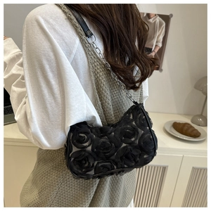 Detail of 3D rose petals on black shoulder bag with metal chain strap and lace fabric