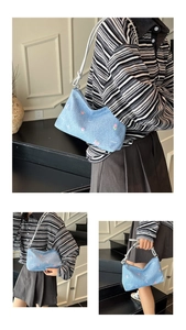 Close-up of blue denim shoulder bag featuring delicate pink tulip embroidery and rope strap