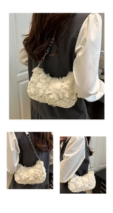 Detail view of 3D layered gauze flowers and silver chain strap on white moon bag