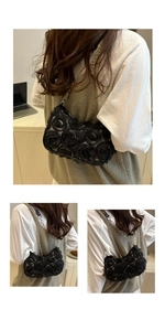 Detail of 3D fabric rose texture and silver chain on a black floral shoulder bag