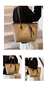 Detail view of large beige tote bag with brown handles and silk scarf ornament