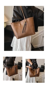 Detail of brown lychee grain leather tote bag with tassels and shoulder straps