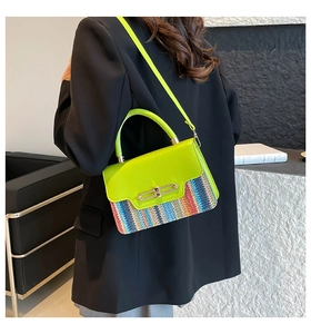 Detail of trendy small square bag with neon green leather and colorful woven stripe pattern