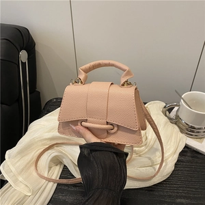 Pink lychee grain leather crossbody bag with top handle shown in a lifestyle setting