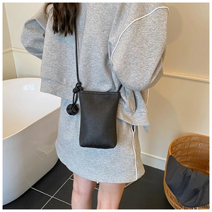 Dettaglio mini borsa a tracolla nera a grana con nodo decorativo sulla tracolla