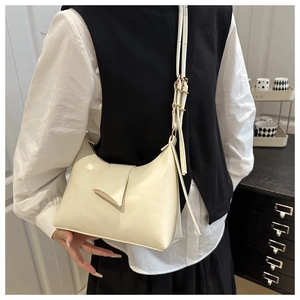 Close-up of cream white crescent shoulder bag with glossy finish and adjustable strap