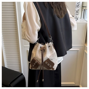 Détail du sac seau en toile avec garniture en cuir brun et cordon sur un mannequin