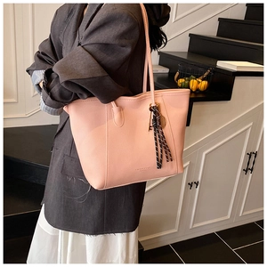 Primer plano del bolso tote rosa grande en cuero sintético granulado con borlas