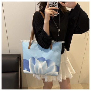 Gros plan sur un grand sac cabas en toile avec imprimé lotus et bordure à franges