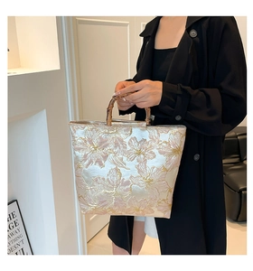 Close-up of golden floral jacquard fabric and vintage bamboo handles on a tote bag