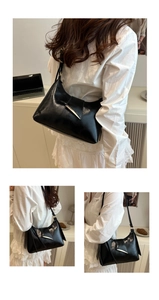 Détail du sac porté épaule noir brillant avec une boucle métallique triangulaire argentée
