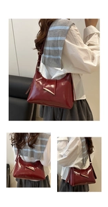 Détail du sac bandoulière en cuir verni bordeaux foncé avec boucle en métal sur modèle