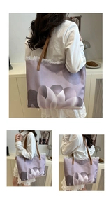 Detalle del bolso tote de lona morada con estampado de tulipanes, flecos y correas de cuero
