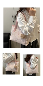 Detail van roze monogram shopper tas met borduursel en pluche beer bedeltje accessoire