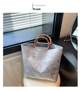 Detail of purple jacquard tote bag with floral patterns and bamboo handle
