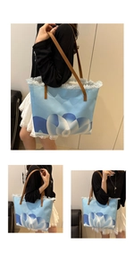 Detalle del bolso tote de lona azul con estampado floral y bordes deshilachados