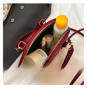 Internal view of dark red patent leather bag showing capacity for cosmetics and skincare
