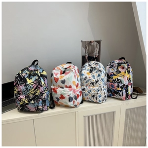 Four canvas backpacks featuring diverse prints including graffiti and floral patterns