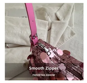 Detailed macro shot of smooth silver zipper and pink sequins on a stylish shoulder bag