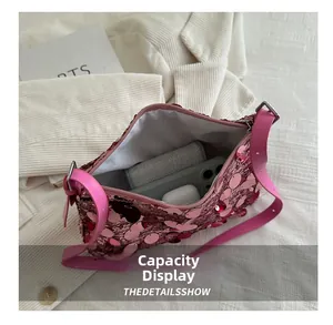 Internal view of pink sequin shoulder bag showing storage space for phone and earphones