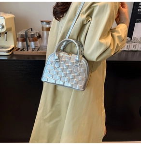 Silver embossed shell handbag with woven texture shown in a casual lifestyle setting