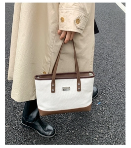Détail de la texture tissée et de la garniture en cuir sur le grand sac cabas chic
