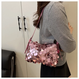 Close-up of pink sequin pillow shoulder bag worn by a model in a trendy party style