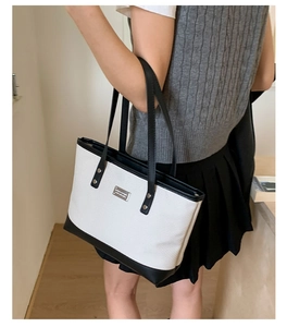 Vue détaillée de la texture en toile tissée et des finitions en similicuir noir du sac