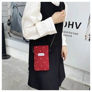 Détail du mini sac bandoulière rouge fleuri en velours côtelé avec étiquette Creative Cat
