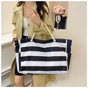 Detail of black and white striped canvas tote with durable white rope handles on shoulder