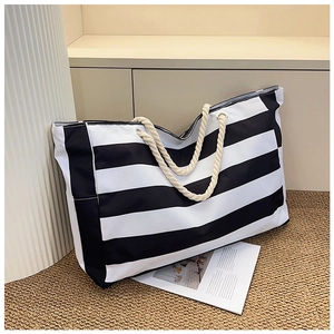 Close-up of black and white striped canvas tote bag with thick cream cotton rope handles