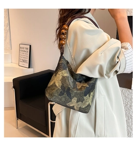 Détail du sac vintage chinois avec jacquard papillon doré et bandoulière en perles de bois