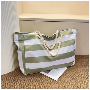 Detail view of large canvas striped tote bag with cotton rope handles and side pockets