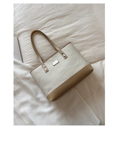 Détail de la texture tissée et de la base en cuir marron clair du grand sac cabas