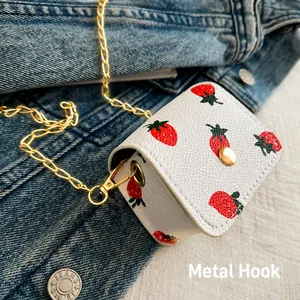 Détail du mini sac fraise avec crochet métallique et bandoulière en chaîne dorée
