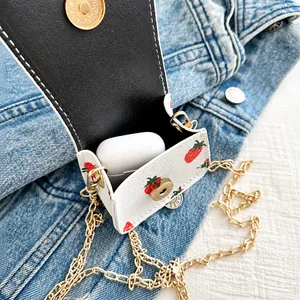 Détail du mini sac blanc à imprimé fraise montrant la capacité pour ranger des écouteurs