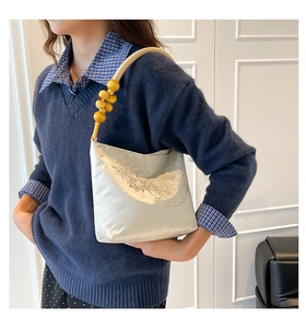 Détail d'un sac seau brodé avec perles en bois et motifs floraux traditionnels chinois