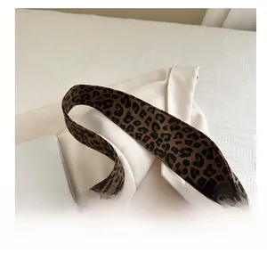 Close-up of leopard print woven strap on a tote bag with durable reinforced stitching