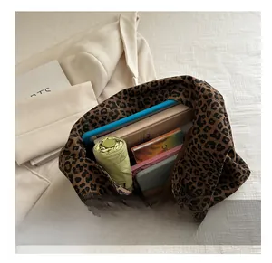 Spacious interior of leopard print tote bag holding a tablet and umbrella