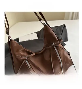 Macro detail of brown tote bag with decorative bows and stylish zippers on smooth texture